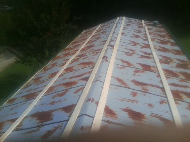 Rusted metal roof panels with new wood purlins before replacement — Storm Damage Roof Repair in Scottsville by Roofing Brothers